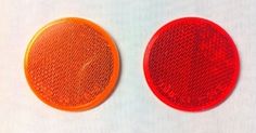 two red and one orange buttons on a white surface