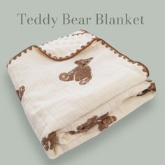 the teddy bear blanket is on display in front of a gray background with brown trim