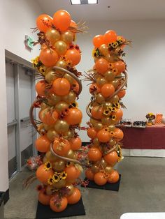 two tall orange and gold balloons in the shape of pumpkins with sunflowers on them