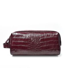 the burgundy crocd leather toiletry bag is made from crocodile skin and features an adjustable strap