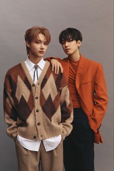 two young men standing next to each other wearing sweaters and ties, one with his arm around the shoulder