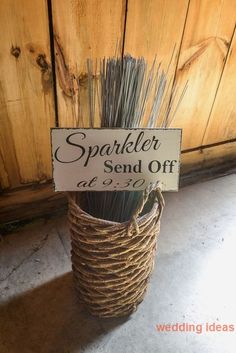 a sign that says sparkler send off in front of a basket with some grass