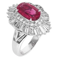 This chic ruby and diamond cocktail ring is crafted in solid platinum, weighing 11.8 grams and 15 mm x 20 mm x 9 mm in height. Showcasing a prominent GIA lab reported oval-shaped, prong-set purplish pinkish red ruby, weighing approximately, 2.29 carats and measuring 10.14 x 6.28 x 3.74 mm. Further accented by (36) baguette diamonds & (20) round-cut diamond, prong-set & channel set at the sides, collectively weighing approximately 1.60 carats, graded G-H color and VS clarity. Currently a US size Formal Oval Ruby Ring In Platinum, Oval Ruby Ring In Platinum For Formal Occasions, Diamond Ballerina Ring, Ballerina Ring, Sparkly Ring, Diamond Cocktail Ring, Pinkish Red, Diamond Cocktail Rings, Modern Ring