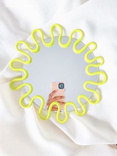 a cell phone sitting on top of a yellow object in the shape of a circle