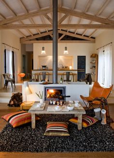 a living room filled with furniture and a fire place in the middle of a room