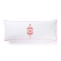 an embroidered pillow with a red and white border