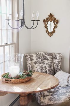 a wooden table sitting in front of a window with a candle on top of it