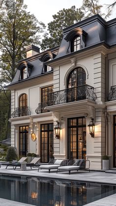 a large house with a pool in front of it and lots of windows on the side