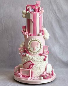 a three tiered cake with pink and white decorations