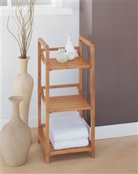 a wooden shelf next to a vase with flowers and a white towel on the floor