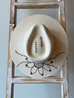 Custom hand-burnt design - Sunflower with vines and arrows Size L - American Hat Makers brand Handmade Adjustable Hat With Round Crown, Handmade Adjustable Round Crown Hat, White Artisan Hand Painted Hats, Painted Hats For Women, Burning Hats, Burnt Hats, Cowboy Hat Crafts, Burned Hats, Cowboy Hat Design