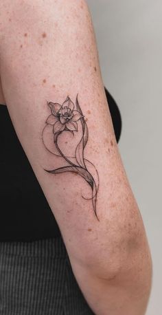 a woman's arm with a flower tattoo on the left side of her arm