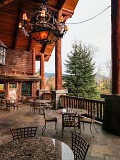 an outdoor dining area with tables and chairs on the patio, overlooking a mountain view