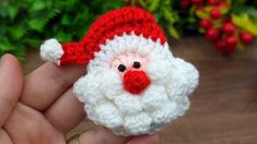 a small crocheted santa claus ornament in the palm of someone's hand