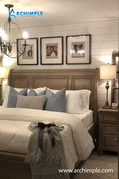 a large bed sitting in a bedroom next to two lamps and pictures on the wall