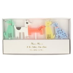 three candles in a white box with dogs on them and the words meri mee 5