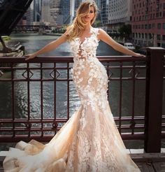 a woman in a wedding dress standing on a bridge