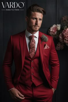 a man wearing a red suit and tie with flowers in the backgroung