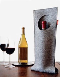 a bottle of wine and two glasses on a table with a corkscrew holder