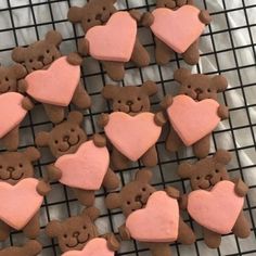 some cookies that are shaped like bears and hearts on a cooling rack with one cookie in the shape of a heart