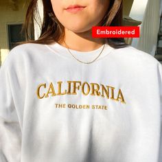 "*SIZES ARE UNISEX* -I'd suggest your usual size for a more fitted look, or sizing up for a more relaxed fit. *these sweatshirts are extra comfy when oversized \"California The Golden State embroidered on a comfy vintage-style crewneck. If you're on the lookout for both style and comfort, this retro sweatshirt is the perfect choice. * 50% cotton, 50% polyester * Pre-shrunk * Classic fit with no center crease * 1x1 athletic rib knit collar with spandex * Air-jet spun yarn with a soft feel and red Varsity T-shirt With Embroidered Graphics For Fall, Fall College Embroidered T-shirt, Embroidered Fall College T-shirt, Embroidered Graphics T-shirt For College In Fall, College Sweater With Embroidered Logo And Relaxed Fit, Fall College Embroidered Tops, Fall College T-shirt With Embroidered Logo, College T-shirt With Embroidered Logo For Fall, Embroidered Fall Tops For College