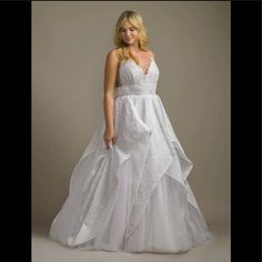 a woman in a white wedding dress posing for the camera with her hands on her hips