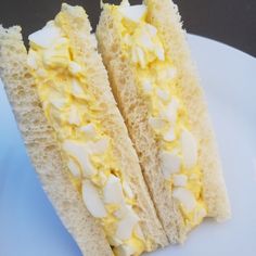 two pieces of white bread with yellow cream on them sitting on a blue and white plate