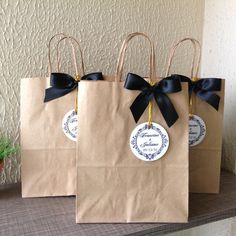 three brown paper bags with black bows on them