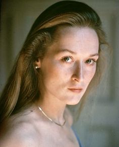 an old photo of a woman with long hair and piercings on her ear, looking off to the side