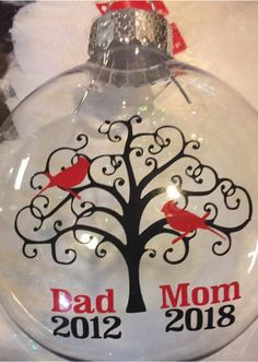 a glass ornament with a tree and two birds on it that says, dad mom 2012