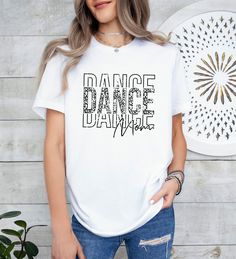 Distressed Dance Mom T-Shirt, Dance Mom T Shirt, Dance Lover Shirt, Gift for Dance Mom, Mothers Day Gift, Dance Shirt, Gift for Her Welcome to TEASHIRT2000! Product Details: For our printing, we've carefully selected Bella Canvas and Gildan SoftStyle brand shirts, renowned for their exceptional quality in the industry. Bella Canvas:     * Available in unisex sizes     * Lightweight at 4.2 oz.     * Solid colors crafted from 100% Combed Cotton and Ring-Spun Cotton.     * Athletic Heather consists White Cotton Tops For Dance, Short Sleeve Graphic Print Tops For Dance, White Casual Tops For Dance, Casual White Top For Dance, White Letter Print Top For Dance Class, White Crew Neck Top For Dance Class, White Casual Dance Top, White Letter Print Top For Dance, White Graphic Print Top For Dance Class