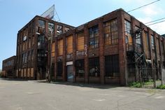 an old brick building with lots of windows and graffiti on it's side wall