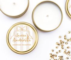 personalized wedding favors in gold and white tins next to some confetti