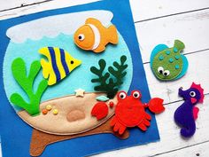 felt sea animals and fish on a blue background with white wood planks in the foreground