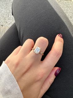 a woman's hand with a ring on her finger and a diamond in the middle