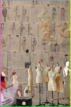 there are many mannequins on display in this room with paper drawings all over the wall