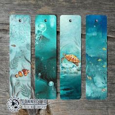 three bookmarks with sea animals on them sitting next to each other in front of a wooden background