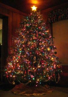 a brightly lit christmas tree in the corner of a room