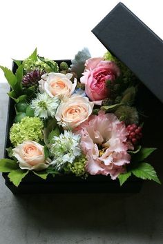 an open black box with flowers in it