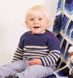 a little boy that is sitting on the ground