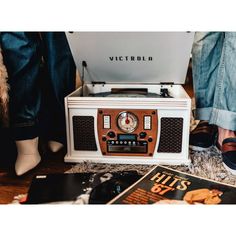 two people sitting on the floor next to an old fashioned radio and record player,