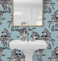 a bathroom with zebra wallpaper and a mirror