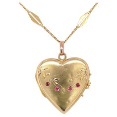 18K yellow gold heart shaped locket with applied green gold leaves and 4 small synthetic ruby accents. There is a French eagle hallmark on the loop attached to the heart. The heart also has engraved leaves and branches. The synthetic rubies each measure about 1.3mm. There are some minor dings and dents. The locket measures 1 1/4" long with bail and 15/16 or just under 1" wide. The 18K gold chain has 18 specialty diamond shaped links and measures 24". The necklace weighs 6.23dwt. It dates from the 1940's. Heart Shape Locket, Heart Shaped Locket, Leaves And Branches, Vintage Locket, Heart Necklaces, 18k Gold Chain, Vintage Lockets, Gold Locket, Rose Gold Heart