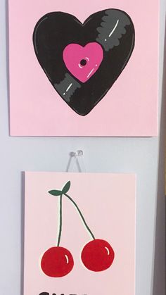 two paintings with cherries hanging on the wall next to each other, one has a heart