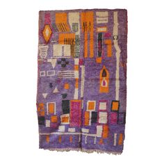 a purple and orange rug with different colored designs on it, including squares, rectangles, and shapes