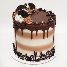 a chocolate cake with white frosting and oreo cookies on top