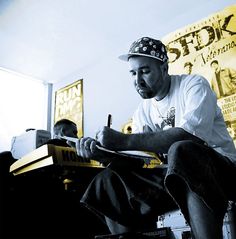 a man sitting down writing on a piece of paper