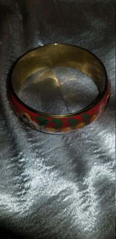 Thick Red floral enamel bracelet Enamel over brass with a red background and yellow and orange flowers with hints of gold and green leaves. Some tarnish on inside but otherwise in very good condition 2 1/2 In. inner diam best for a smaller wrist Just a teensy bit under one inch thick Red Metal Cuff Bracelet Bangle, Red Metal Bangle Cuff Bracelet, Vintage Handmade Red Bangle, Vintage Red Round Bangle, Festive Red Metal Bangle, Red Round Metal Bangle, Red Bracelets For Festivals, Red Bohemian Metal Bangle, Red Metal Bohemian Bangle