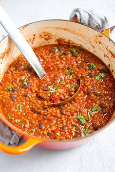 a pot filled with beans and garnished with cilantro on the side