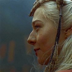 a close up of a person wearing a head piece with braids on her hair